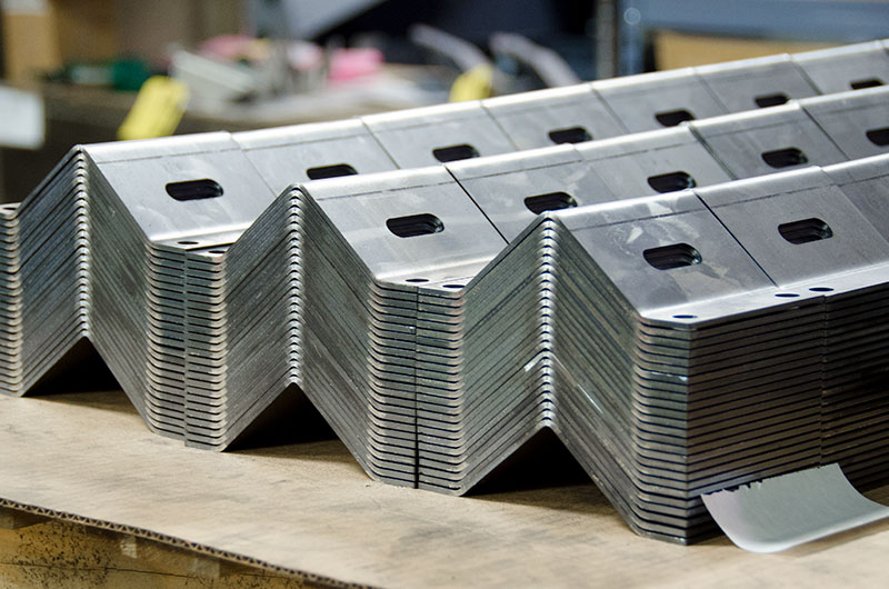 Angled sheet metal components are stacked and ready to be shipped.