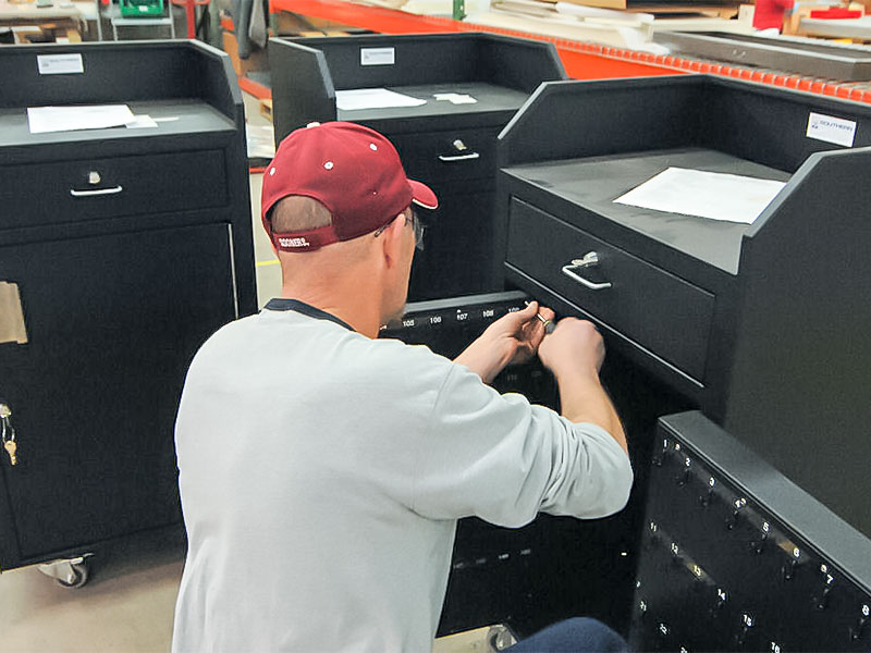 A Southern Specialties technician installed hook components for a valey key cabinet.